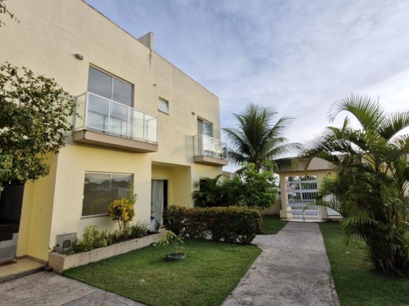 Fachada de village moderno para alugar em Itapuã com jardim frontal