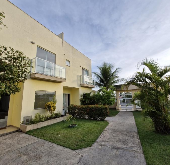 Fachada de village moderno para alugar em Itapuã com jardim frontal