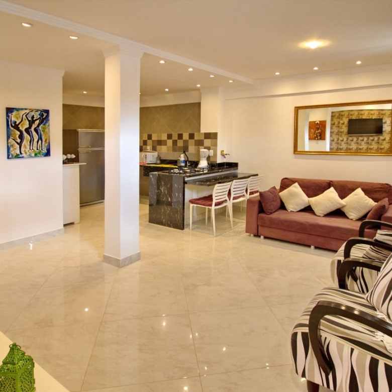 Sala com sofá, poltronas e TV da casa à venda no Village Sossego, Vilas do Atlântico