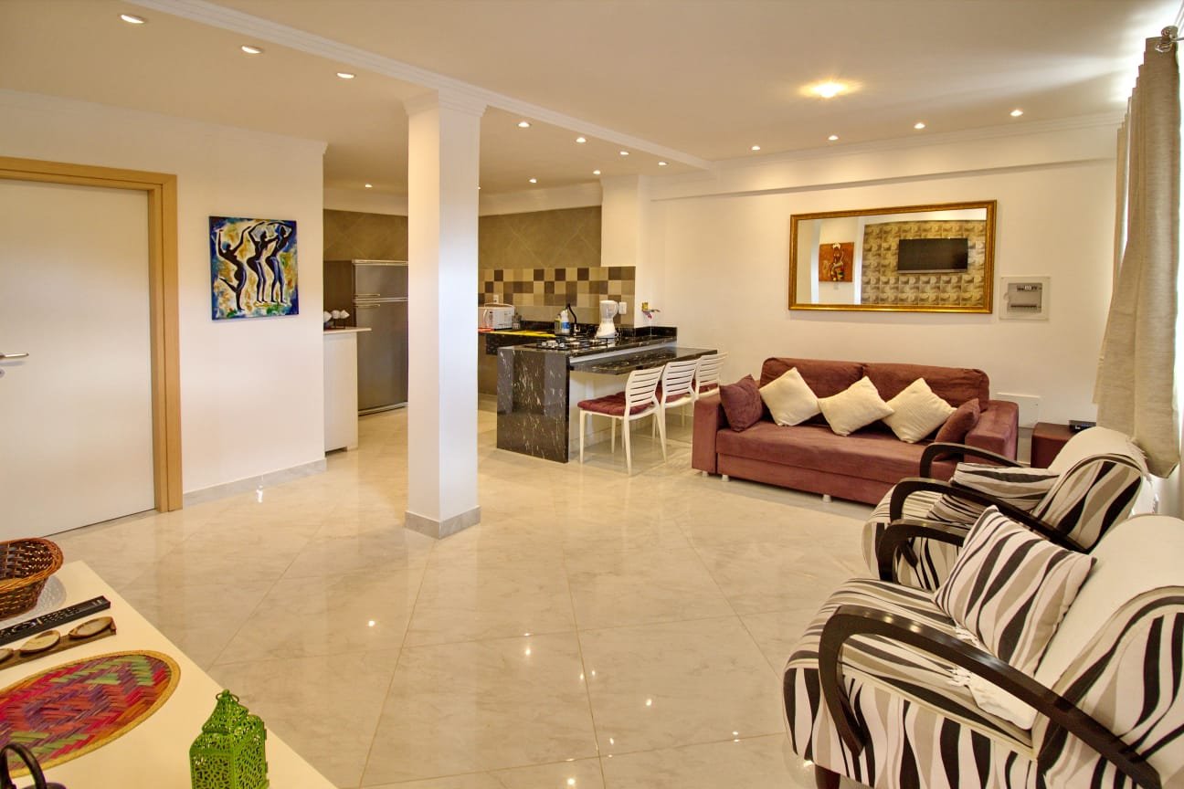 Sala com sofá, poltronas e TV da casa à venda no Village Sossego, Vilas do Atlântico